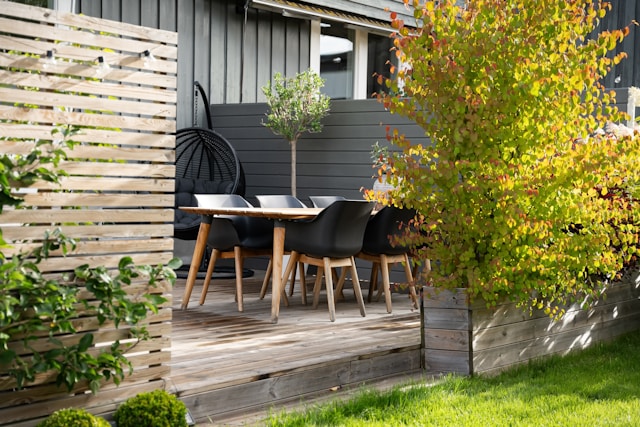 a-patio-with-a-table-and-chairs-next-to-a-fence-